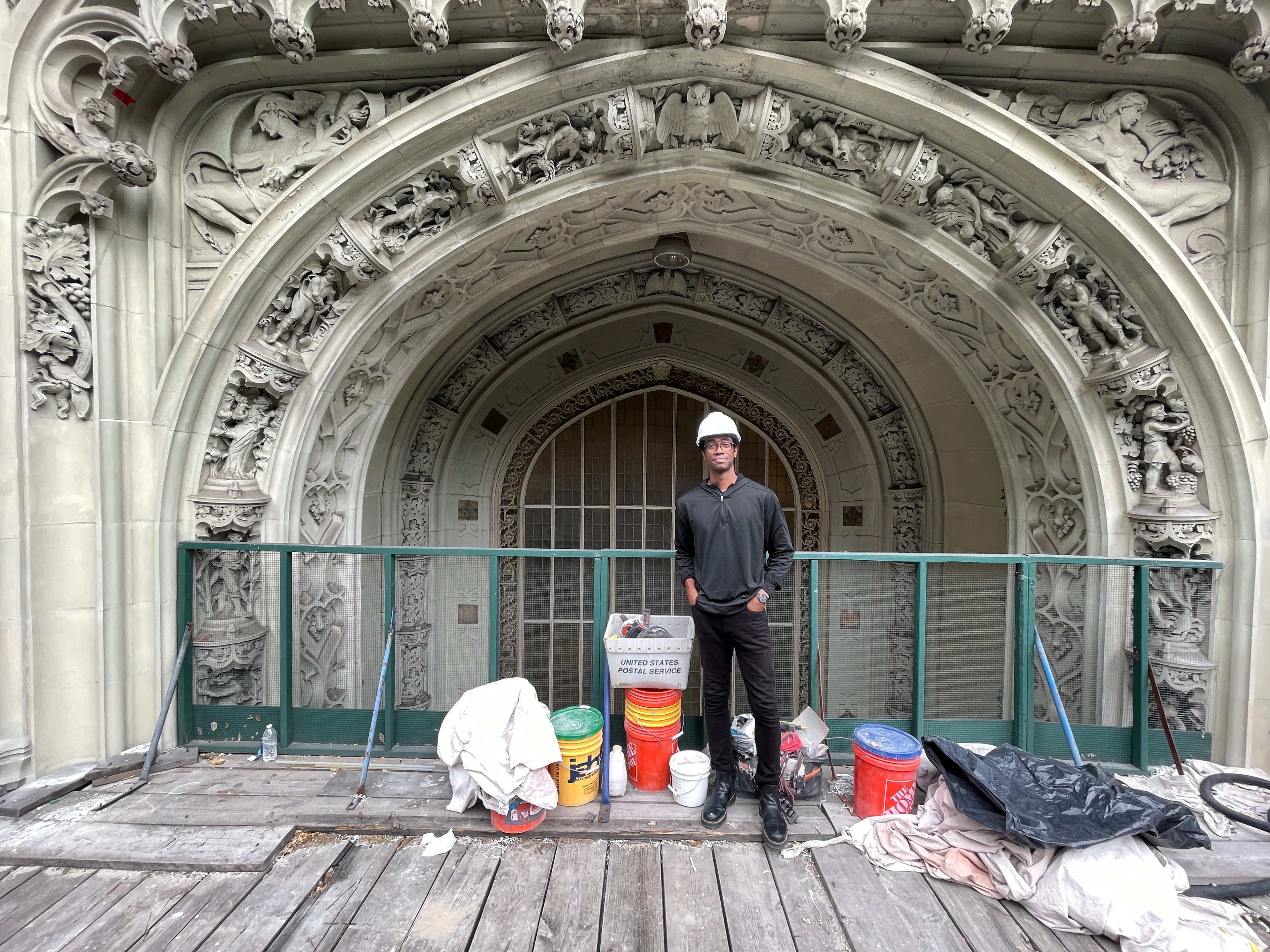 Jeremy Edwards standing beneath the Woolworth Building's ornamental limestone arch