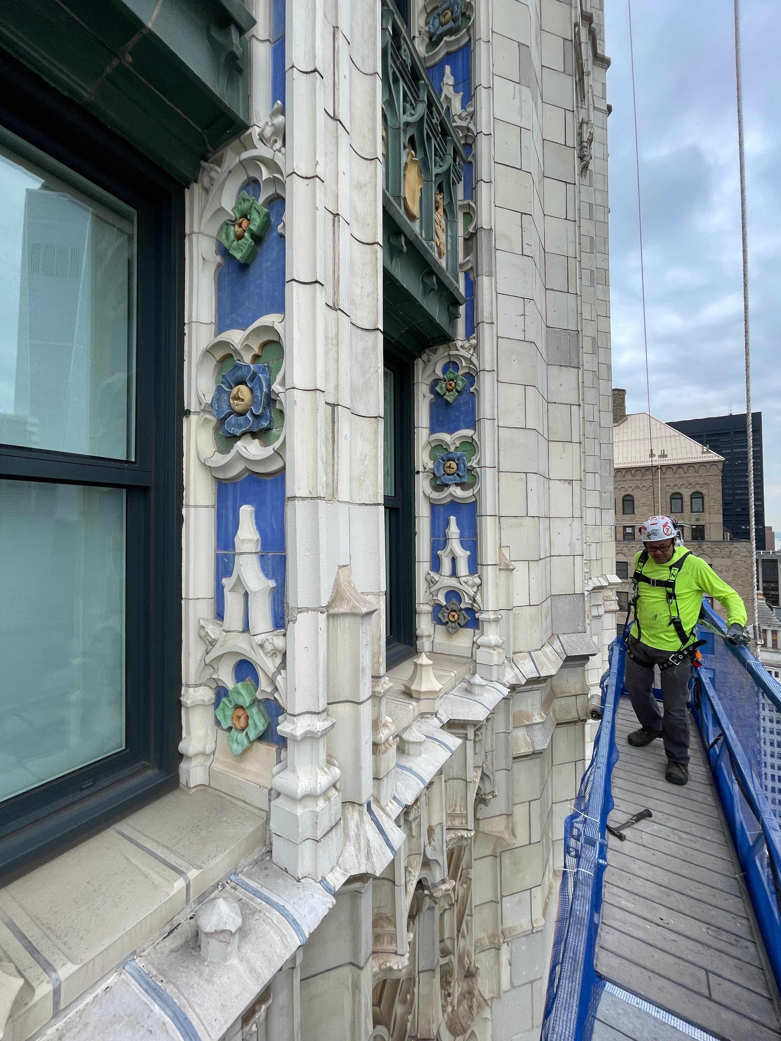 Polychrome terra cotta flowers and window surrounds beside a suspended scaffold