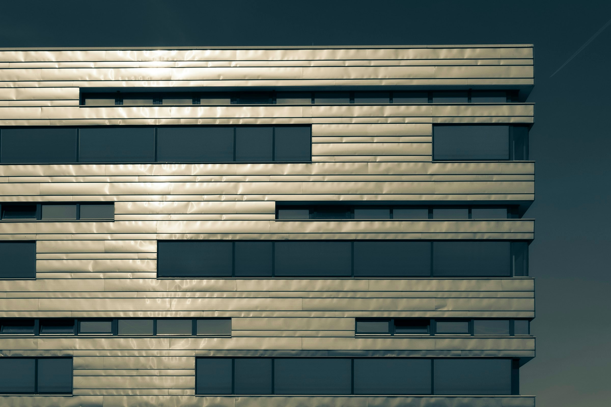 Layered horizontal architectural metal panels and windows on a contemporary facade