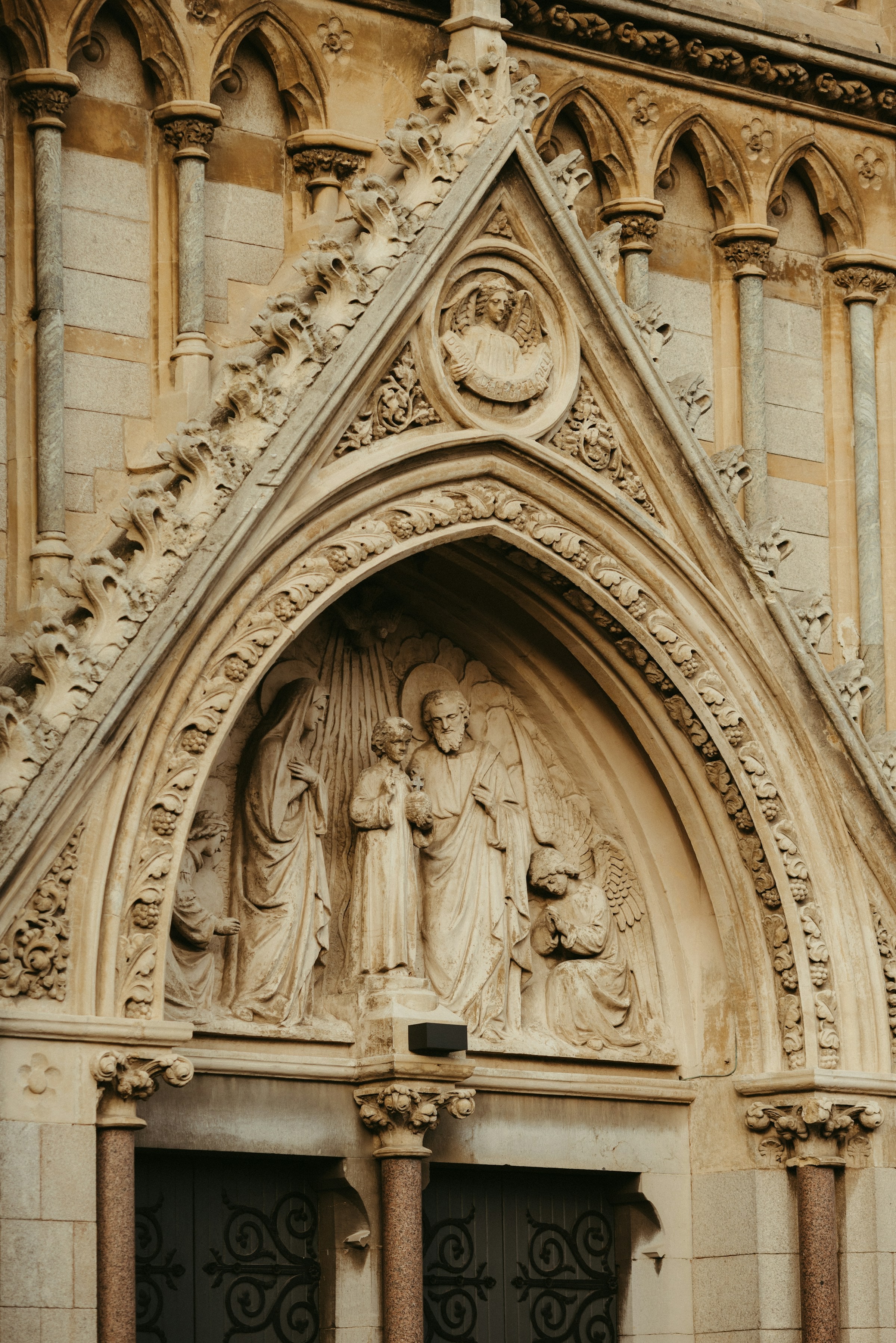 Carved stone figures and Gothic ornament above an arched doorway in Dublin