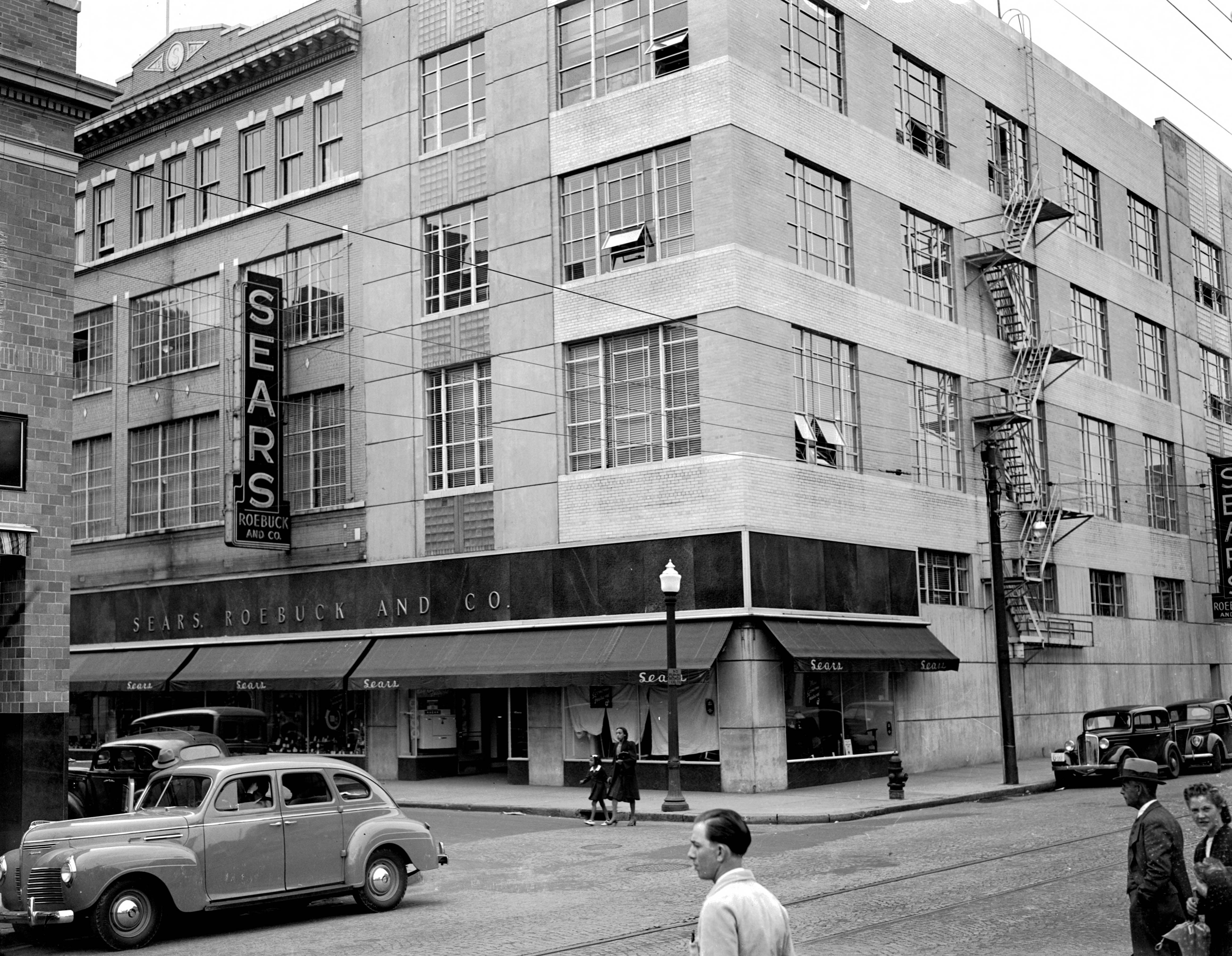 The Monticello Avenue entrance in 1940, showing the curved corner, horizontal bands, glass block, and original storefront composition.
