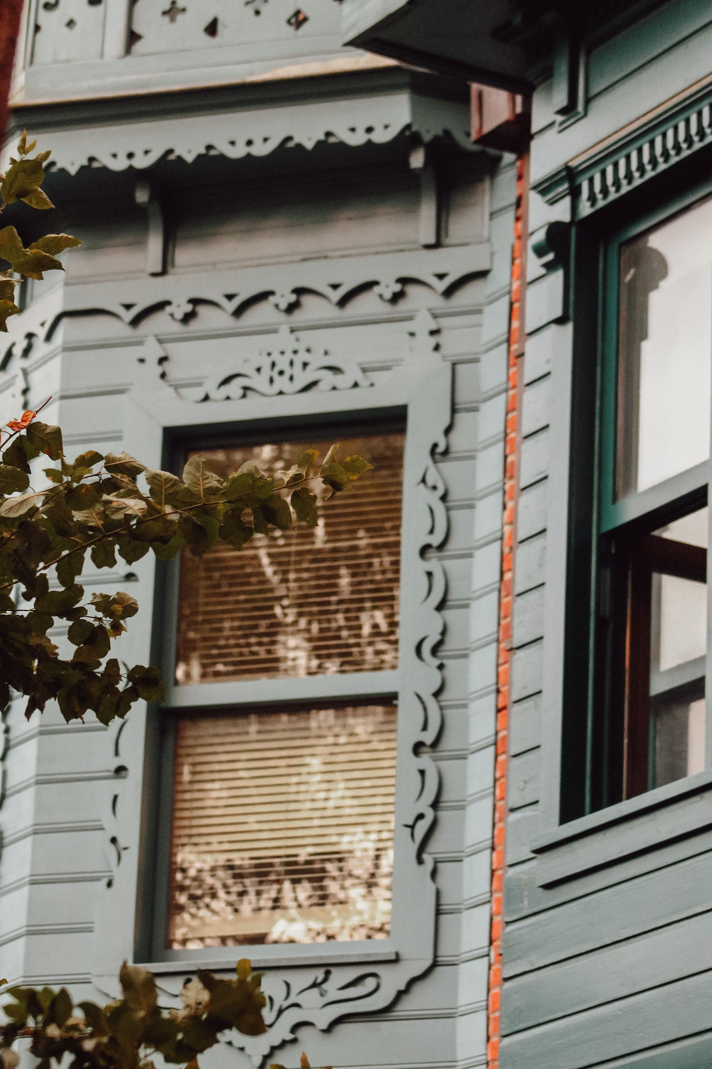 Painted wood window surrounds and decorative trim on a Victorian house